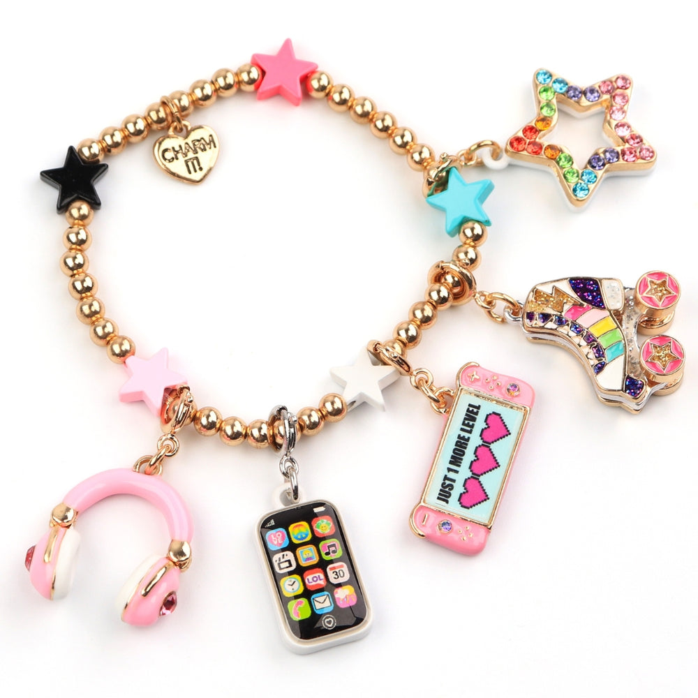 A gold-tone bead charm bracelet featuring various pop culture and fashion-themed charms, including a pink heart-shaped star, a rainbow star, a roller skate charm, a pink headphone charm, a phone charm, and a heart-shaped charm