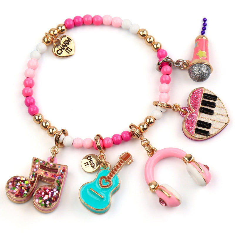 CHARM IT! pink bead charm bracelet with gold-tone hardware and multiple music-themed charms, including a glitter musical note, a Rebel Girls guitar, pink headphones, a piano heart charm, and a star microphone charm - charmit.com.